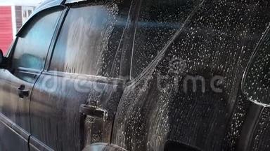 汽车自动洗车过程.高压清洗汽车泡沫的喷水器 侧面